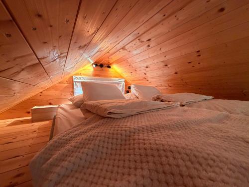 a bedroom with a large bed in a wooden ceiling at Dushka Mountain Cabin in Belec