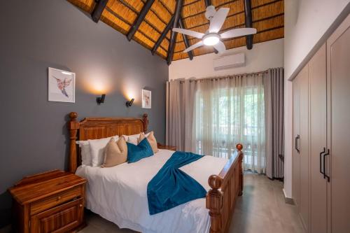 a bedroom with a bed and a ceiling fan at Kruger Park Lodge - Modern Unit 225B in Hazyview