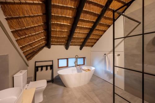 a bathroom with a white tub and a sink at Kruger Park Lodge - Modern Unit 225B in Hazyview