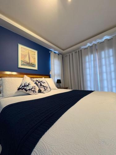 a bedroom with a large bed with blue walls at Pousada Banzay in Paraty