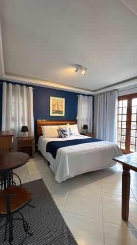 a bedroom with a large bed with blue walls at Pousada Banzay in Paraty