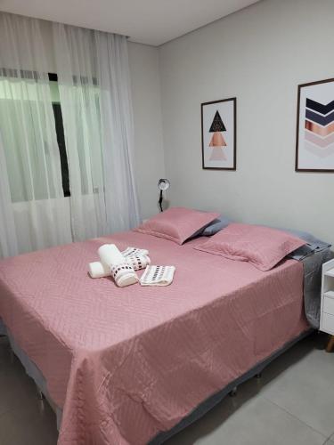 a pink bed with two towels on top of it at Diamond - Flat Bela Estância in São Lourenço