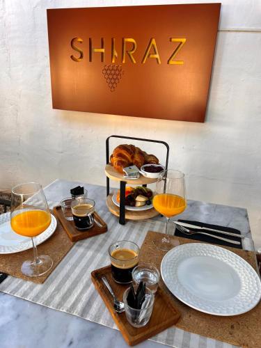 a table with glasses of orange juice and a tray of food at Hostal del vino LA COSTERA in Altea