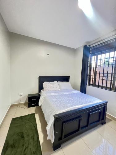a bedroom with a bed and a large window at Luxury Ntinda Apartment with Wi Fi and Netflix in Kampala