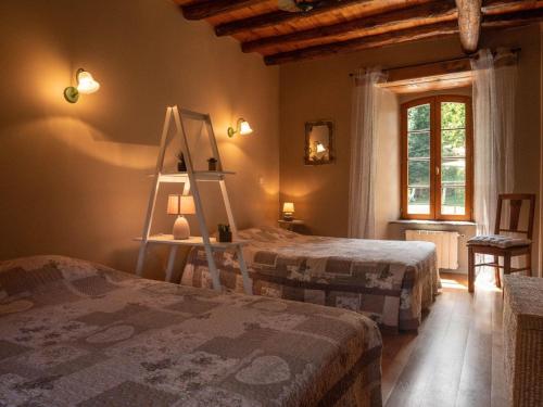 a bedroom with two beds and a ladder and a mirror at Presbytère st michel de léon in Lacaze