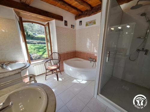 a bathroom with a tub and a sink and a shower at Presbytère st michel de léon in Lacaze