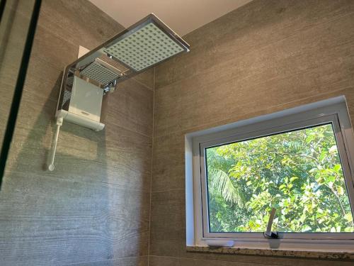 a bathroom with a window in a shower at Suítes Bela Vista in Pomerode