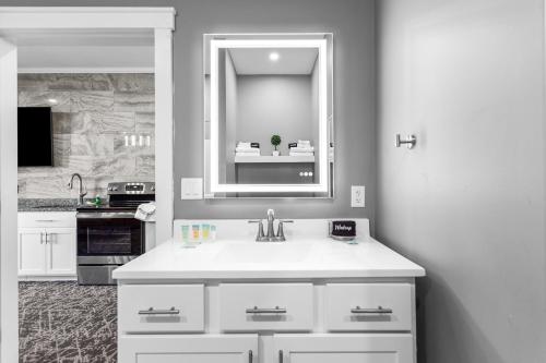 a white bathroom with a sink and a mirror at Stone Park Ellsworth-Bar Harbor in Ellsworth