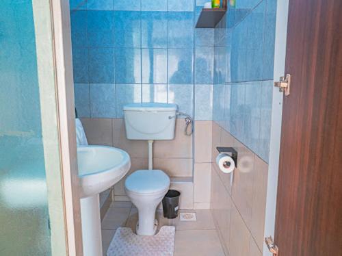 a small bathroom with a toilet and a sink at Easy Stay Rongai Poolside 2BR near Karen WiFi and Netflix in Ongata Rongai 