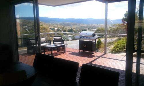 a screened in porch with a grill on a deck at Jindabyne Guest House in Jindabyne