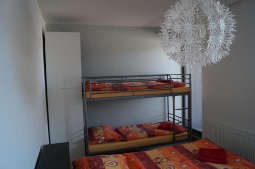 a room with two bunk beds and a chandelier at Apartments Klinovec in Loučná pod Klínovcem