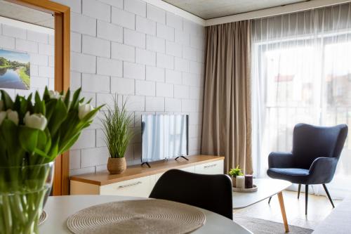 a living room with a tv and a table and chairs at River Side Apartments in Oświęcim