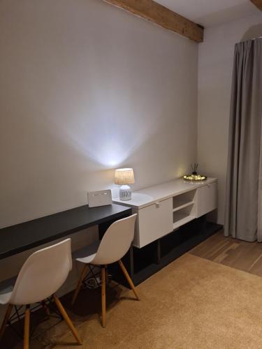 a room with a desk with two chairs and a lamp at Lovely 1-bedroom condo in Riga