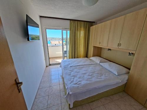 a bedroom with a bed and a large window at MIRKO DIVING CENTER in Rab