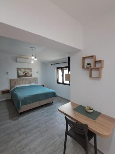 a bedroom with a bed and a desk and a table at Apartmani Račeta in Kotor