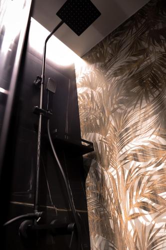 a room with a wall with a wallpaper with plants at 115 Luxury Suite - Privitera in Grammichele