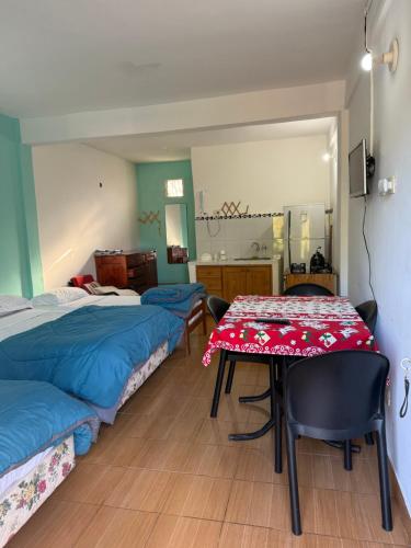 a room with two beds and a table and a mirror at Nathaly aparts iguazú in Puerto Iguazú