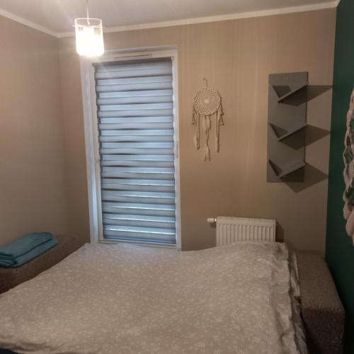 a bedroom with a bed and a window with a skull on the wall at Apartament pod dębami in Trzcianka
