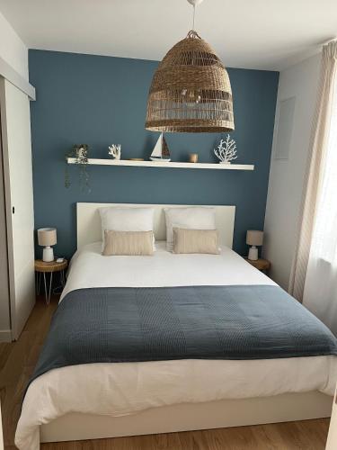a bedroom with a large bed with a blue wall at La Dune Dorée Escapade Croteloise in Le Crotoy