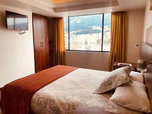 a bedroom with a bed and a large window at Los Angeles Stay Inn in Quito