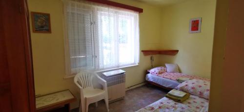 a small bedroom with two beds and a window at Ildi nyaraló in Gárdony