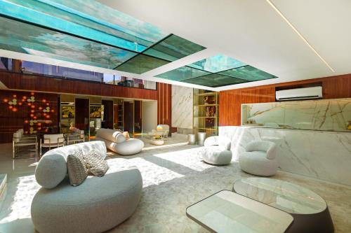 a living room with white furniture and a glass ceiling at Pousada Apple House Paraty in Paraty