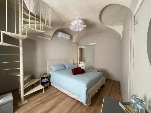 a bedroom with a bed and a spiral staircase at Dimora del Loggiato in Acqui Terme