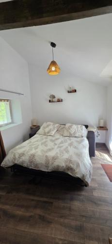 a white bedroom with a bed and a chandelier at Studio Mazalys-Entre Mer et Campagne in Crépon