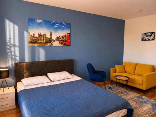 a bedroom with a bed and a yellow couch at Apartman Lanass Doboj in Doboj
