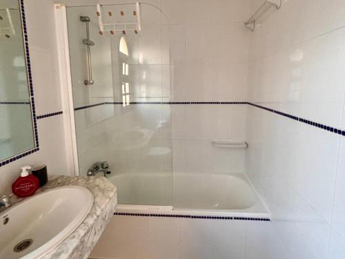 a white bathroom with a tub and a sink at fuerte blue in Costa Calma