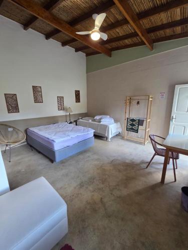 two beds in a large room with a ceiling at Villa Dona Jaca - Cabana 01 in Socorro