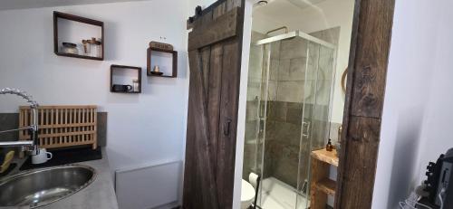 a bathroom with a wooden shower and a sink at Studio Mazalys-Entre Mer et Campagne in Crépon
