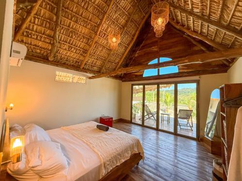 a bedroom with a bed and a large window at Seúl Haus in El Sunzal