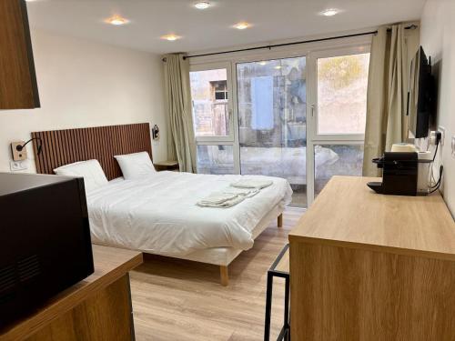 a bedroom with a bed and a tv and a window at Studio 2 neuf RDC hyper centre-ville in Bar-le-Duc