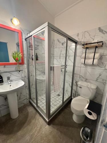a bathroom with a shower and a toilet and a sink at The Jungle Hotel and Bar in Bocas Town