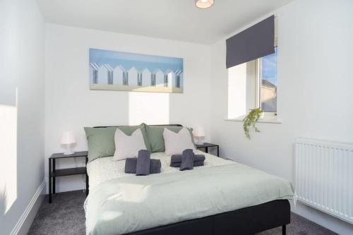 a white bedroom with a bed with blue pillows at Spacious 5BR - Heart of Galashiels -Group Friendly in Galashiels