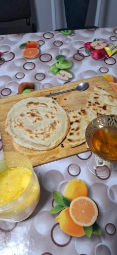 a table with a cutting board with food on it at Cozy Stay Emir in Kazarman