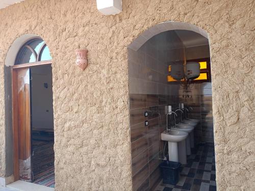 a bathroom with a row of sinks and a mirror at Manzil Al-Wahati in Bawati