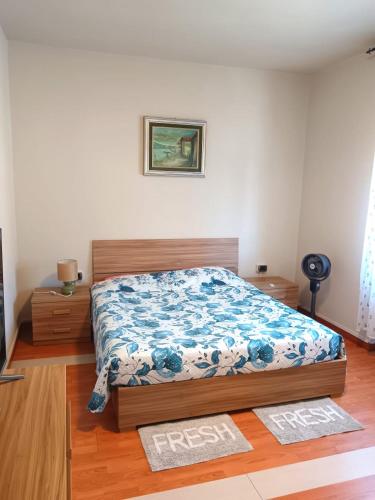 a bedroom with a bed with a blue and white comforter at Vin's Apartment in Adro