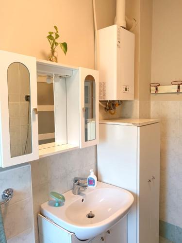 a bathroom with a sink and white cabinets at Vin's Apartment in Adro