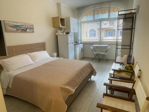 a bedroom with a large bed and a kitchen at Ashur mondello in Palermo