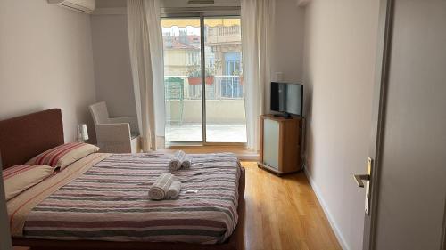 a bedroom with a bed and a tv and a window at Appartamento Sole in Nice