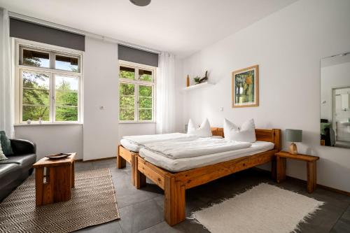 a bedroom with a bed and a couch and windows at Hotel Bolter Mühle - DZ Gerstenkammer in Rechlin
