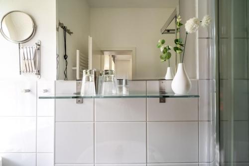 a bathroom with a glass counter with vases and a mirror at Roggenkammer in Rechlin