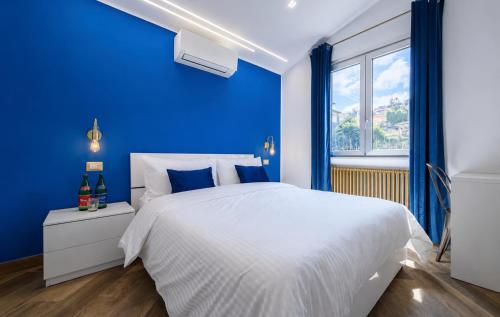 a blue bedroom with a white bed and a window at Villa In Bed in Naples