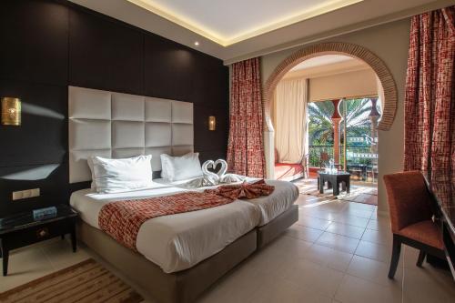 a bedroom with a large bed and a large window at Delta Hotels by Marriott Marrakech Eden Andalou in Marrakesh