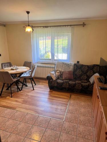 a living room with a couch and a table at Domek u Krzyśka in Słopnice