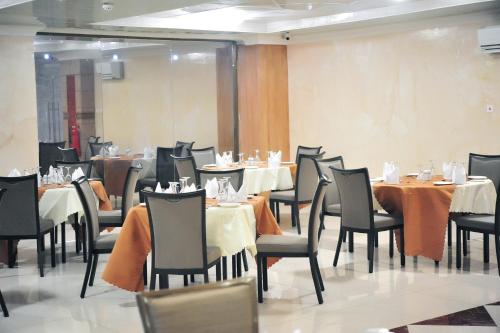 Tomreik Hotel في آكرا: مطعم فيه طاولات وكراسي في الغرفة