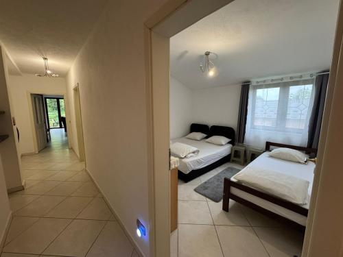 a room with two beds and a hallway at Apartmani Natura in Sanski most