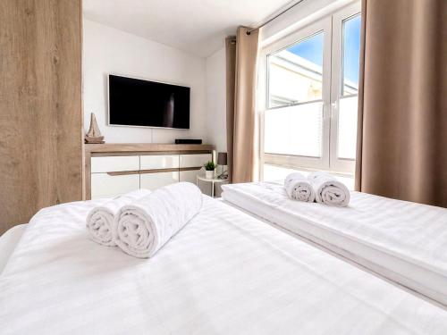 a bedroom with two white beds and a tv at Floating Comfort in Peenemünde in Peenemünde